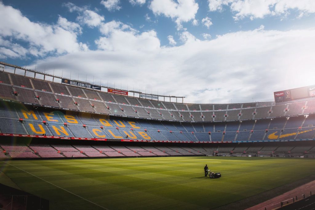 pexels-photo-2413089 A vibrant football stadium with a well-maintained grass field under a bright sky, showcasing its iconic architecture.